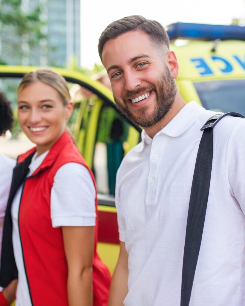 Multi-ethnic paramedics standing at the fromt of an ambulance. Emergency doctor and nurse standing in front of ambulance Multi-ethnic paramedics standing at the fromt of an ambulance. Emergency doctor and nurse standing in front of ambulance